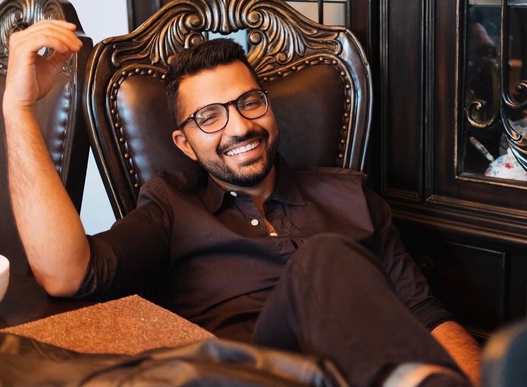 Masood Suliman smiling while seated in a leather chair at his Ottawa clinic.