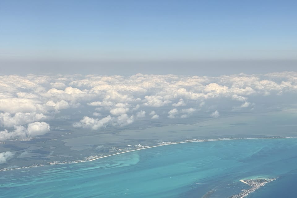 An island surrounded by turquoise water, seen from above.
